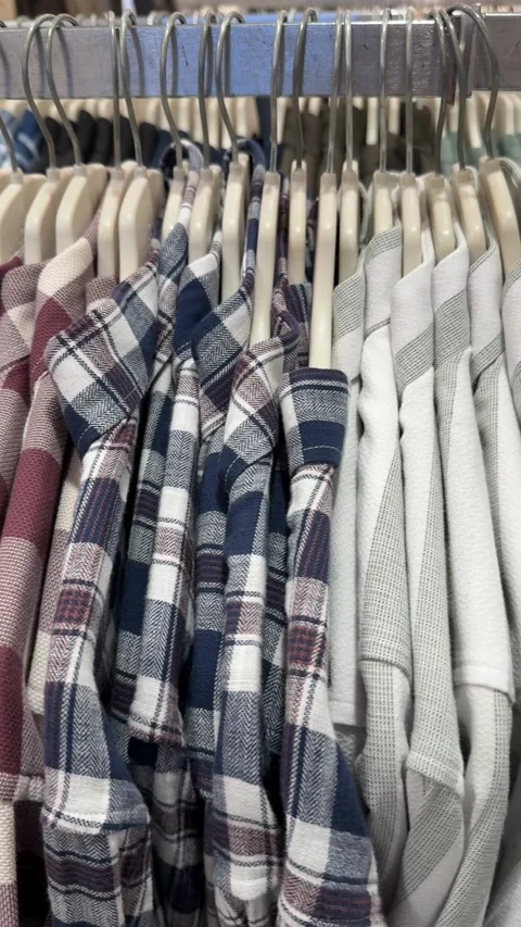 Plaid shirts hanging on a rack in a store showcasing different patterns and.. Stock Footage 332304018