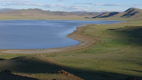 Plain and lake on a background of mountains and a cloudy sky. Stock Footage 89676423