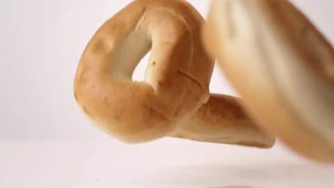 Plain bagels bouncing on white slow motion macro food studio 4K stock Stock Footage 336527050