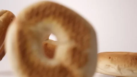 Plain bagels bouncing on white slow motion macro food studio 4K stock Stock Footage 336705999