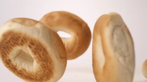 Plain bagels bouncing on white slow motion macro food studio 4K stock Видео 337909745