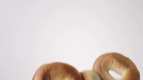 Plain bagels raining on white slow motion macro food studio 4K stock Stock Footage 337909929