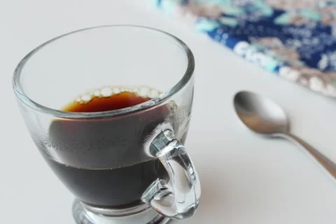 Plain black coffee inside a transparent glass espresso coffee cup. Video stock 292782029