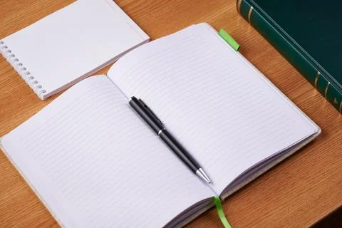Plain Blank Open Notebooks With Stack Of Pens Inside Container Placed On Top Of Foto stock