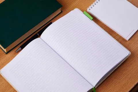 Plain Blank Open Notebooks With Stack Of Pens Inside Container Placed On Top Of Stock Photos