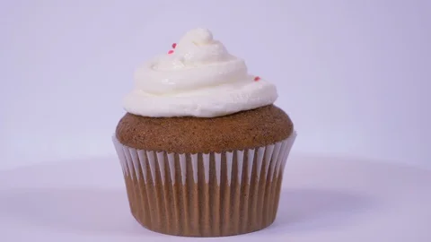 Plain Cupcake Spinning with sprinkles falling on it over white background 스톡 동영상 128153848