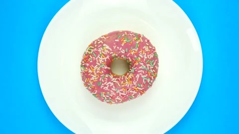 Plain donut on a plate rotates 360 degrees, top view Stock Footage 166748879