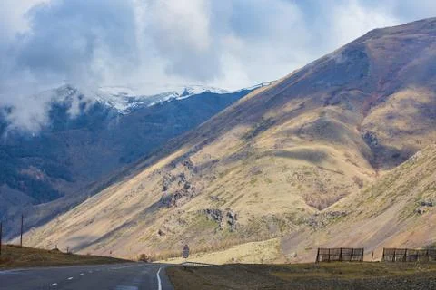 Plain with highway at root of mountains Stock Photos