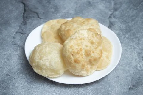 Plain Luchi or golden, puffed puri bread artfully stacked on a pristine whi.. 写真素材