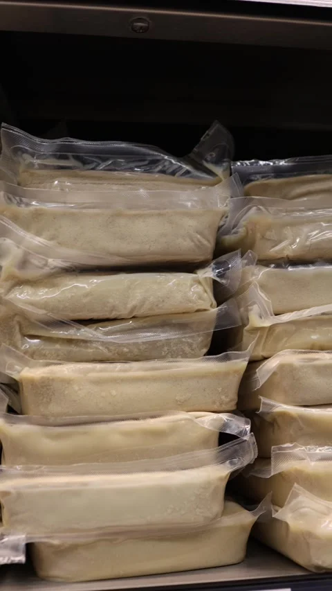 Plain tofu blocks vacuum sealed and stacked on a refrigerated store shelf Stock Footage 345978449