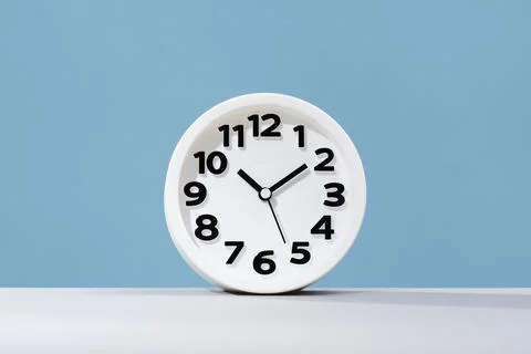 Plain wall clock on pastel blue banner Stock Photos