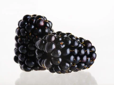 On a plain white background, two blackberries. Tasty, healthy, diet food, lig Stock Photos