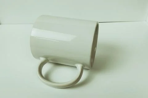 Plain white mug on a white table Stock Photos