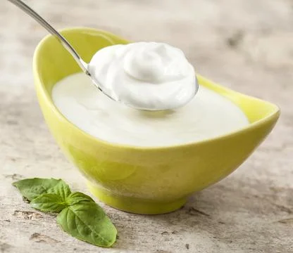 Plain yogurt in the glass jar on table Stock Photos