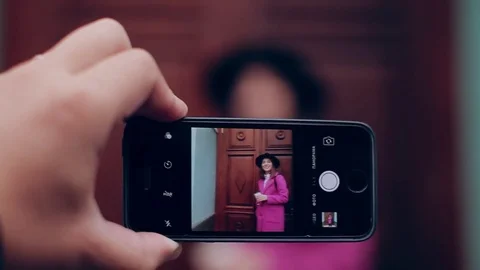 Plan big guy takes on smartphone Woman in black hat and pink coat Stock-Footage 71219797