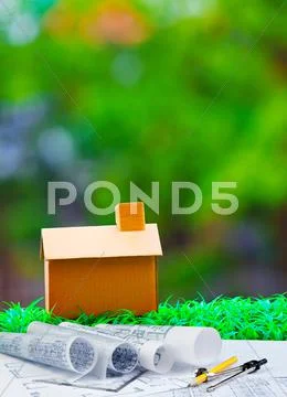 Plan compass and paper work with home on green grass with blur background Stock Photos