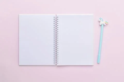 Plan, list. An open, clean notepad and a blue pen with a pony on a pink backg Stock Photos