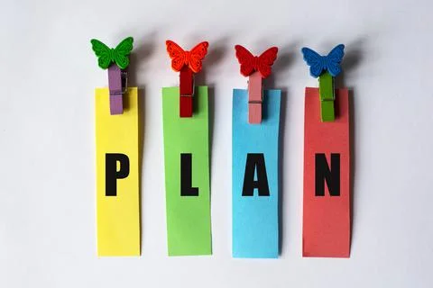 PLAN on multicolored stripes with clothespins on a white background Stock Photos