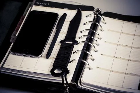 Plan for murderer - calendar, planner, cellphone, pen and knife as weapon Stock Photos
