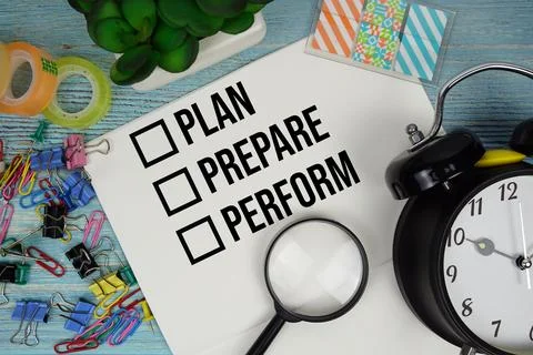 Plan, Prepare, Perform text on a paper surrounded by office supplies, a mag.. Stock Photos