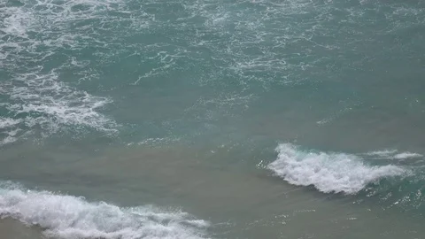 Plan view of seascape with arriving waves crashing on sandy shore. 4K Vidéo 72706126