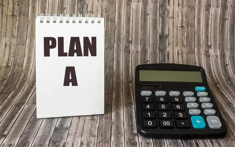 Plan A written on a notepad, next to a calculator on a wooden background. Bus Stockfoto's