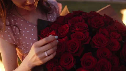 Plan with a young woman's engagement ring, while holding a bouquet of roses in 库存影片 140878102