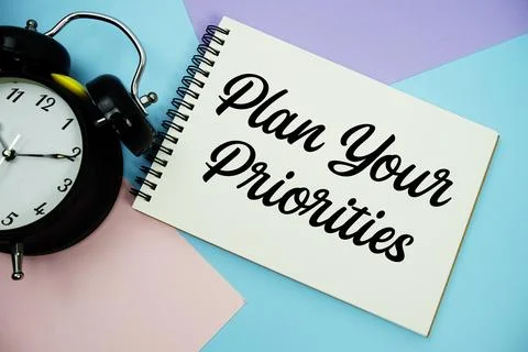 Plan Your Priorities text written on notepad with alarm clock flat lay on m.. Stock Photos