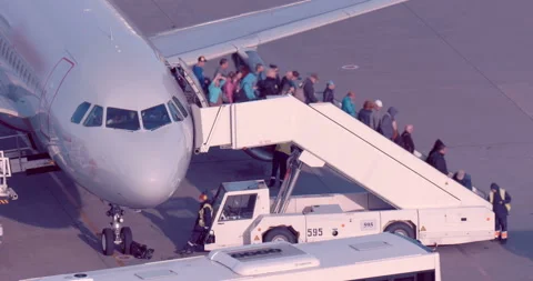 The plane after landing, passengers descend a ramp and board the arriving buses Stock Footage 119583072