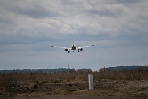 Plane almost landed at the runway. Engine heat behind the plane. 库存照片