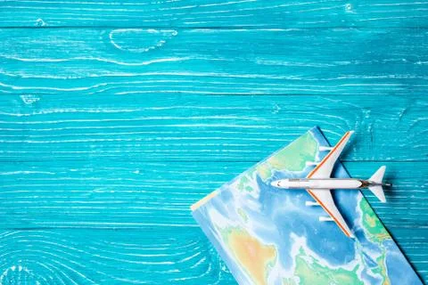 Plane and map located on blue wooden background Stock Photos