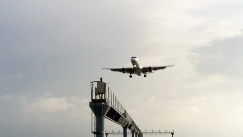Plane approaching at very low altitude at sunset from the ocean, to land at t Stock Footage 130072050