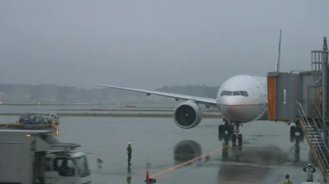Plane arrives to gate in rain Stock Footage 605445