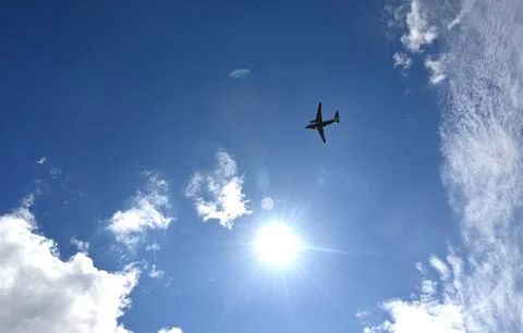 A plane in a bare sky with clouds. The concept of the world. Stock Photos