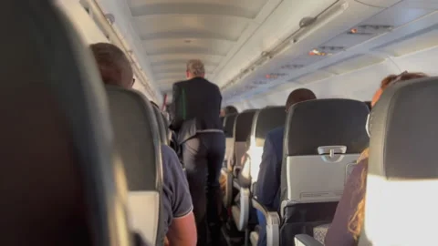 Plane corridor aisle. Passenger seated inside airplane traveling in flight Stock Footage 229962264