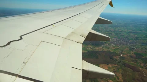 Plane descending over fields and small town. Jet lowering altitude above Vídeos de archivo 333580383