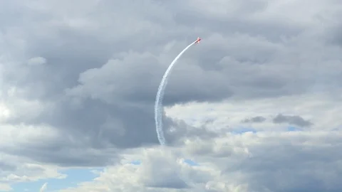 A plane is doing advanced aerobatics high above the city. Stock Footage 121252524