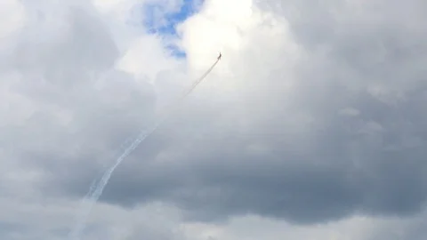 A plane is doing advanced aerobatics high above the city. Stock Footage 121252584