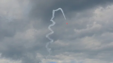 A plane is doing aerobatics high in a grey cloudy sky. Stock Footage 121252322