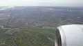Plane engine seen through window, green fields below flying aircraft, travel 4k or 4k+ Resolution