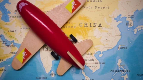 A plane with a flag of Bhutan crossing the map. Stock Footage 143980904