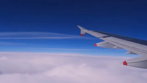 Plane flies above the clouds and blue sky Stock Footage 75855632