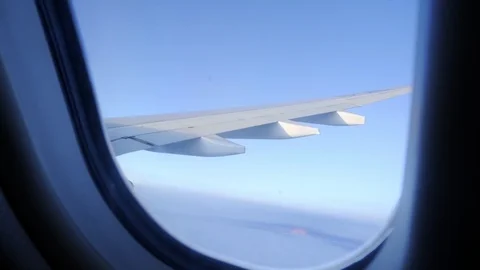 The plane flies above the clouds. View from the porthole to the sky. Video stock 117753513