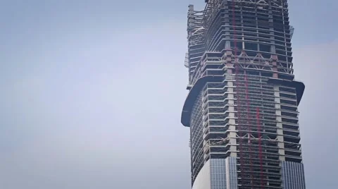 The plane flies behind a skyscraper under construction Video stock 58214767