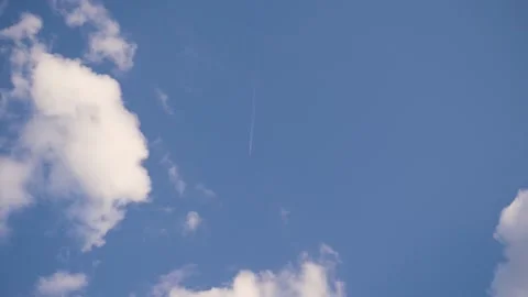 Plane flies in distance,leaving two white stripes behind it.Sunny summer day. Stock Footage 130727301