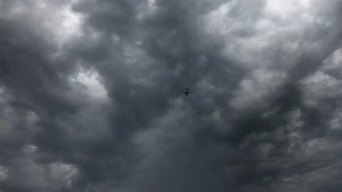 The plane flies in the evening sky through heavy clouds. Stock Footage 144413843