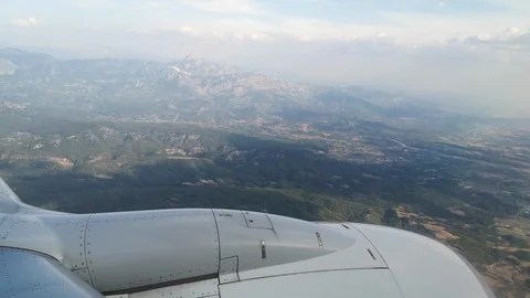 The plane flies low over the valley among mountains - 26s Stock Footage 119506596