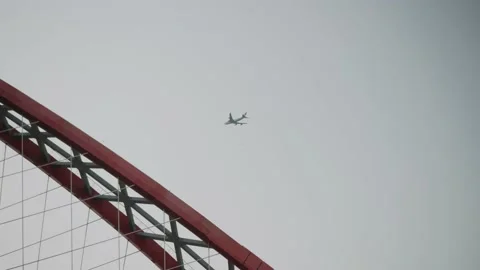 The plane flies over the bridge Stock Footage 156642869