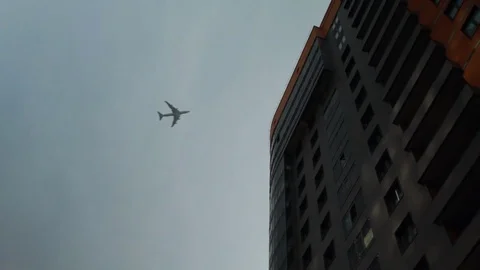 The plane flies over the city Stock Footage 76458635