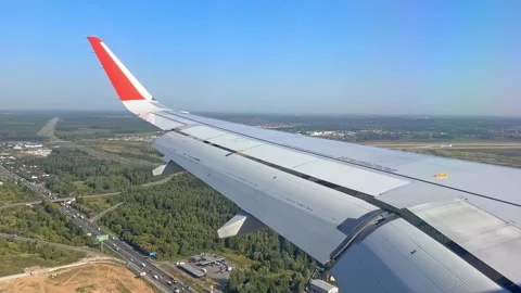 The plane flies over the city, preparing to land on the runway Stock Footage 305592423